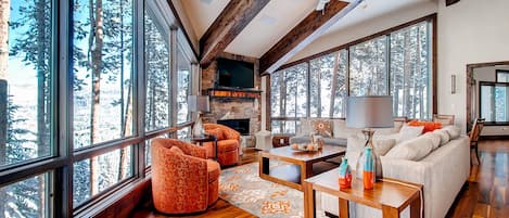 Great room with fireplace and wooded views