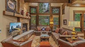 Great room on main level with gas fireplace, TV, and deck access