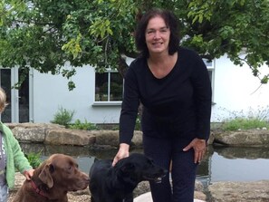 Your host Helen with her Labrador Sam and a guest dog (natural koi pond behind)