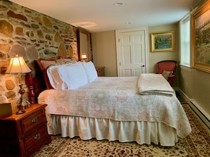 Main Bedroom with Queen Bed and fieldstone wall. 