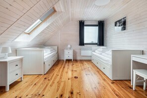 Cosy attic bedroom with two single charming white beds.