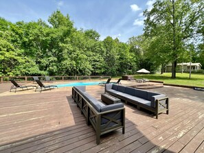 Large deck with plenty of seating, hot tub, picnic table, grill, basketball pad.