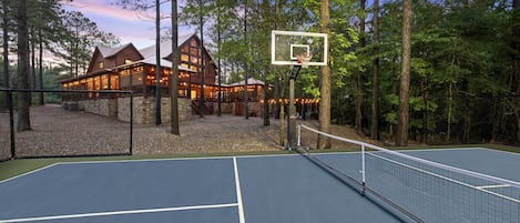 Huge backyard with lighted pickleball court, big fire-pit, custom playset with two slides, and lots of open play space.
