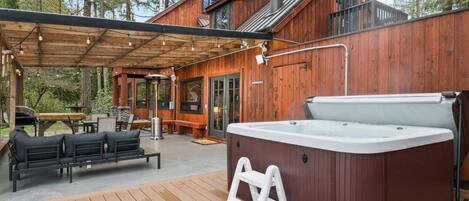 An absolutely epic deck featuring, seating, heating, hot tub, BBQ, and gorgeous waterfront views.