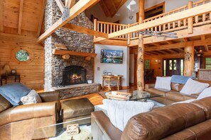 Great Room with Stacked Stone Fireplace and High Vaulted Exposed Beam Ceiling
