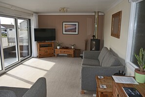 Living room with log burner and access to the balcony,