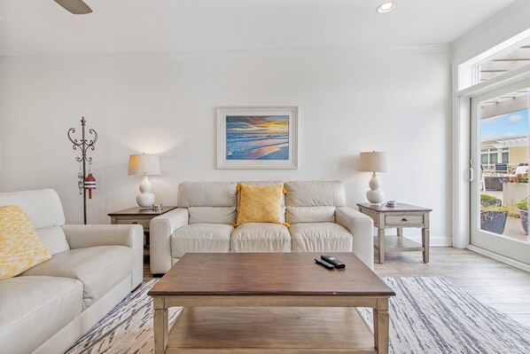 Living room with comfortable seating and access to 4th floor patio areas.