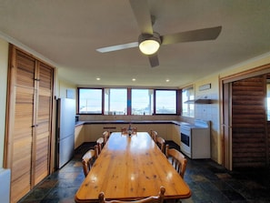 Includes a large front deck with sea views, a pergola-covered dining space, fire pit, paved and grassed backyard zones, outdoor shower, and a dedicated surfboard rack.