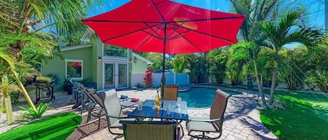 Turtle Tyme outdoor dining set with pool & home in background