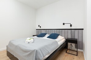 A peaceful bedroom retreat with a double bed dressed in neutral bedding, modern wall art, and blackout blinds for ultimate privacy and rest. A combination of style and comfort makes it perfect for restful nights.