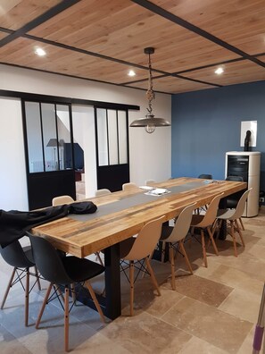 salle à manger avec une table pour 12 convives et poêle à granulés bois.