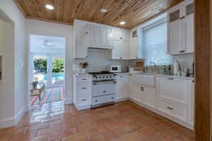 Gorgeous newly upgraded kitchen with stainless steel double door refrigerator, white Farmhouse style gas range, stove, Nespresso Vertuo 3 coffee maker, toaster and new white counter tops.