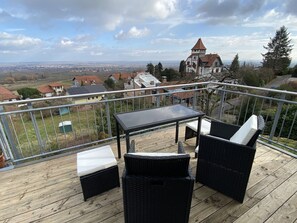 Balkon mit bequemer Bestuhlung und Ausblick auf die Wohnlage am Ortsrand 