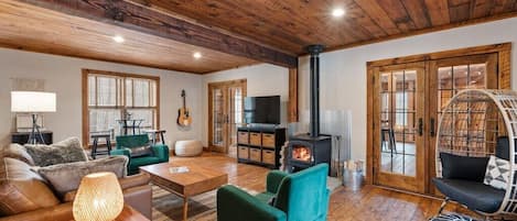 With ceilings and walls adorned with white pine boards harvested from the land the home sits on, the main living room is professionally decorated with seating for 10.