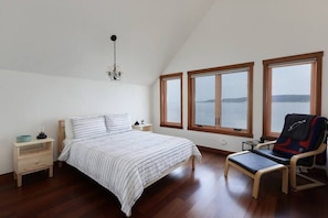 Loft bedroom on the second floor has high vaulted ceilings and 180° oceanfront view