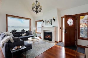 Living room has high vaulted ceilings take takes advantage of the 180° of the ocean and mountains