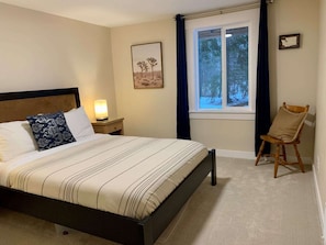 One of the two queen bedrooms on the main floor with yard views.