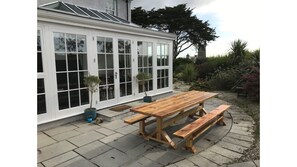 light flooded orangery with seating area and table tennis opens up to pizza/BBQ