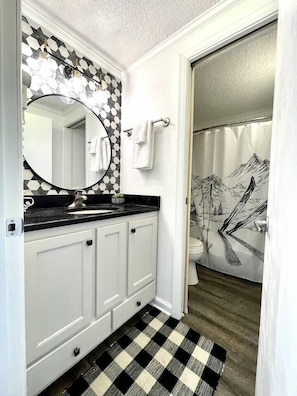 Renovated bathroom features a pocket door so one person can be in the shower while someone else is using the sink area. (Not many units have this, it's a great help to getting multiple folks ready at the same time!)