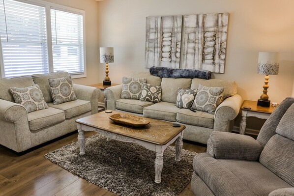 Nice living room with a couch, loveseat and a recliner.