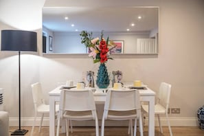 Our dining area features a cozy table and chairs, perfect for intimate meals with loved ones or for catching up on work while savoring a delicious meal. We are partners with Tablescape London and they arranged this beautiful table arrangement.