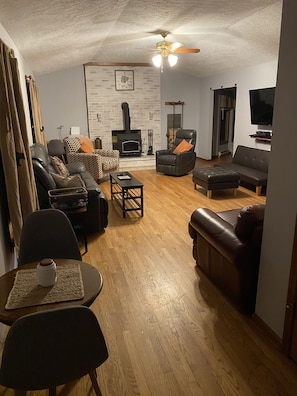 Living room- wood burning stove, futon, pullout sofa bed, game table, desk,