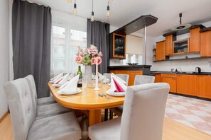 A cozy dining area with wooden furniture and a stylish table, seamlessly connected to the kitchen for an open-plan layout.