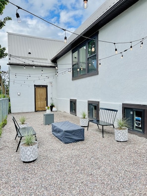 Outdoor lounge area with gas fire pit, grill, & table & night lights