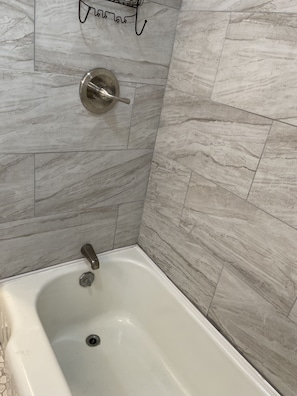 Bathtub with new tile in downstairs bathroom