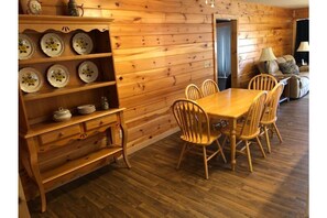 Seating and place settings for 6 people including plates, glasses and flatware.