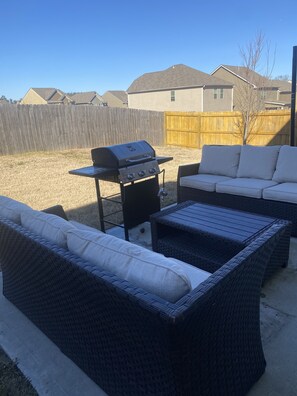 Fence in backyard with patio furniture 
