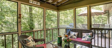 Screened-in porch paradise surrounded by lush greenery for tranquil moments.