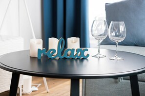 The living area features a sleek coffee table and a flat-screen television.