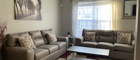 Large great room with ceiling fan. Lots of natural light.