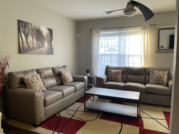 Large great room with ceiling fan. Lots of natural light.