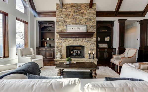 Elegant living space with stone fireplace and mountain view.