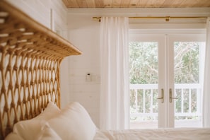 Luxurious king-size rattan bed in the Cocomo Cottage suite.