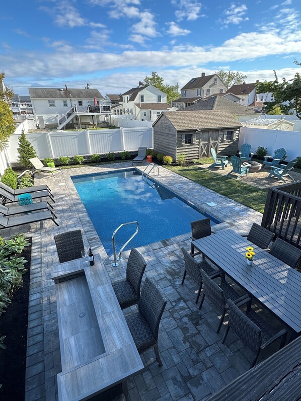 NEWLY RENOVATED BACKYARD with heated 80 degree salt water pool. Fire pit area