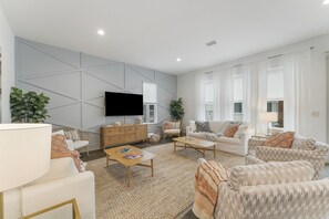 The living room features a 65 inch Samsung smart TV and plenty of seating for gathering.