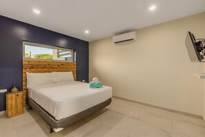 A queen size bedroom with a wooden headboard and comfortable bed frame and mattress perfect for couples.