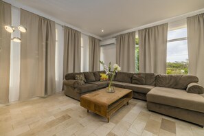 You can just lay down and relax while watching your favorite live streams or just take in the green surroundings in this living room with a large comfortable sofa