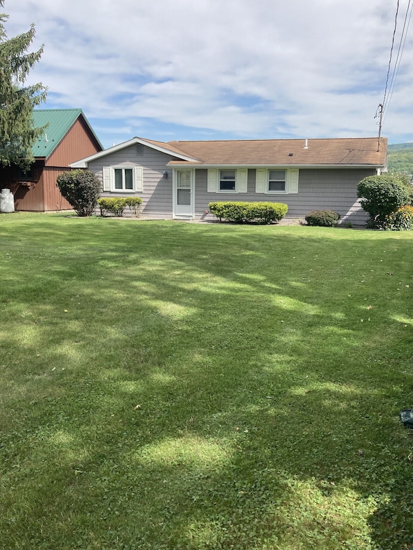 Great view of the cottage front with large lawn 
