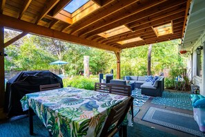 Covered patio with BBQ, dining table, sectional, fans & pool toys