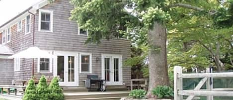 Back of house with full deck, pool fence off to the right 