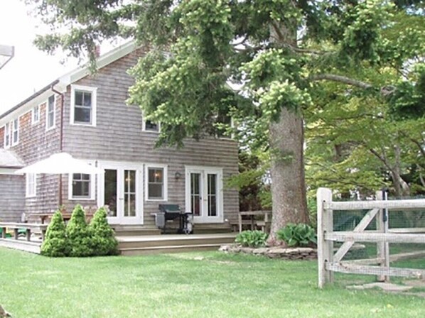 Back of house with full deck, pool fence off to the right 