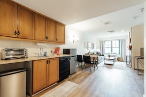 Galley kitchen with stove top, microwave, med sized fridge, etc