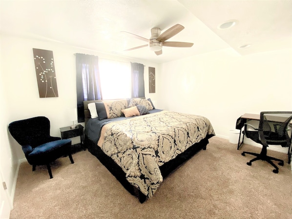 King bed with walk in closet and a desk to work at.
