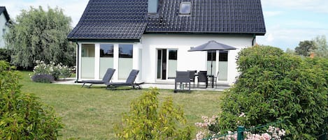 Haus mit Terrasse und großem Rasen-Grundstück