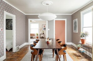 The heart of the house, featuring a huge mahogany table framed by a Herman Miller pendant with smart lighting