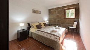 Bedroom with a comfortable double mattress. Soft towels and linens included! There's also a gorgeous stone wall and an AC unit #cozy